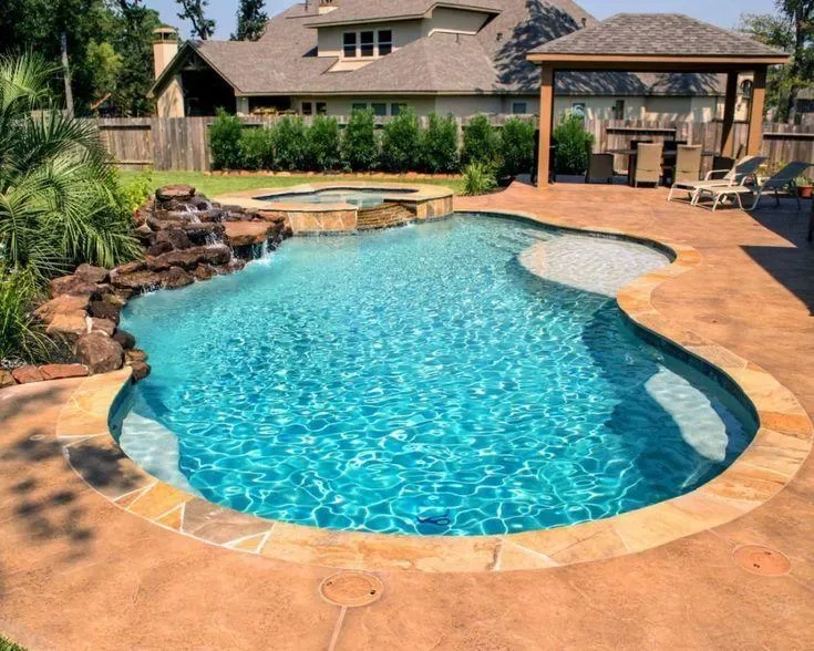 Crystal-clear freeform pool with umbrella and stone deck serviced by Endless Blue Pools in Round Rock, TX